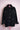 Black corduroy button-up jacket with lace-trimmed chest pockets on pink mannequin