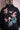 Black denim jacket with embroidered birds, pink blossoms, and blue-green leaves on the back