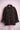 Black corduroy jacket with red bead embroidery on shoulders, button-down front, and rolled cuffs on pink stand