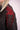 Close-up of black textured jacket shoulder with intricate red beaded floral embroidery and chain detail