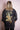 Back view of a woman wearing black distressed denim jacket with gold and multicolor embroidered phoenix design