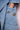 Close-up of hand in light blue denim jacket pocket with bee and insect brooch pins