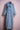 Light blue denim trench coat with double row buttons and embroidered lion patch on chest