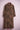 Long brown leopard print trench coat with double-breasted buttons displayed on pink metal stand