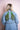 Back view of woman wearing light blue denim jacket with two green peacock patches on the back