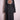 Black denim trench coat with colorful embroidered floral mandala on back displayed on pink hanger
